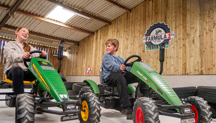 Two children using the Farmula One go karts 